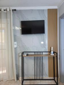ein Wohnzimmer mit einem Fernseher an der Wand in der Unterkunft Lighthouse in Flogita