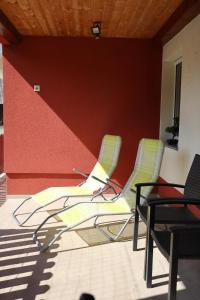 a group of chairs in a room with a wall at Apartment Alana in Podvelka