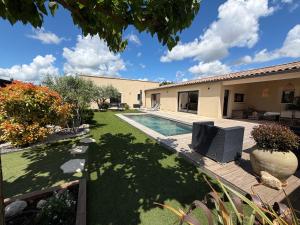 a yard with a swimming pool and a house at L instant provençal in Robion en Luberon