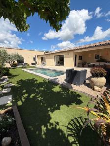 a house with a yard with a swimming pool at L instant provençal in Robion en Luberon