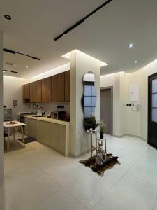 a kitchen with wooden cabinets and a table in it at شاليه لوسيندا in Baljurashi