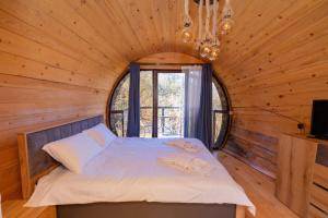 a bed in a wooden room with a window at Cottages Chateau Ochia in Koromkhet'i +13 photos