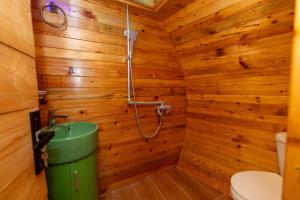 a wooden bathroom with a shower and a toilet at Cottages Chateau Ochia in Koromkhet'i