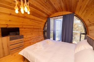 a bedroom with a bed in a wooden room at Cottages Chateau Ochia in Koromkhet'i