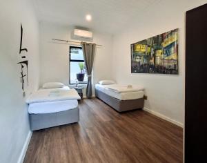 two beds in a room with wooden floors at Getaway between the sea and the mountains in Gordonʼs Bay +27 photos