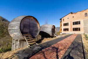 two large wooden barrels sitting next to a building at Cottages Chateau Ochia in Koromkhet'i