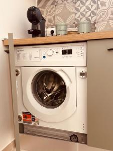 a washing machine under a counter in a kitchen at Eureka Apartment in Noto