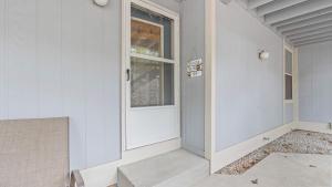 a white door on a white house with a window at By The Lake Resort Access in Lake Ozark