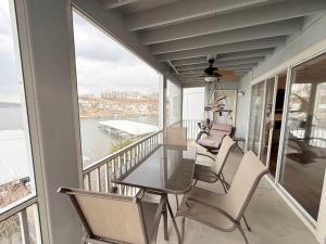 a balcony with a glass table and chairs on it at By The Lake Resort Access in Lake Ozark