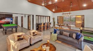 a living room with couches and a pool table at SaffronStays Ivy Courtyard - 5 bedroom & Veg Only Villa in Khopoli in Jambhulpāda