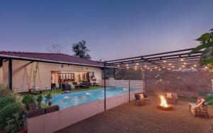 a backyard with a swimming pool and a fire pit at SaffronStays Ivy Courtyard - 5 bedroom & Veg Only Villa in Khopoli in Jambhulpāda