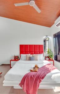 a bedroom with a large white bed with a red headboard at SaffronStays Ivy Courtyard - 5 bedroom & Veg Only Villa in Khopoli in Jambhulpāda