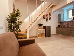 a living room with a couch and a kitchen at Eureka Apartment in Noto