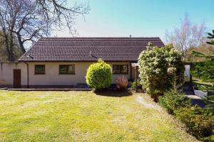 a small white house with a yard at Ardmara in Belladrum