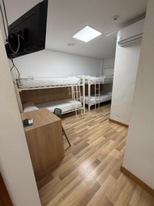 a room with three bunk beds and a television at Bearan Rooms 2 in Pamplona