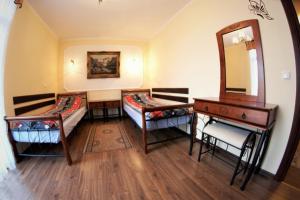 ストロニエ・シロンスキエにあるApartament Morawkaのベッド2台、洗面化粧台、鏡が備わる客室です。