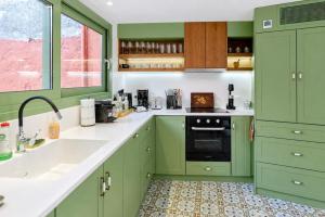 a green kitchen with a sink and a stove at Casa Di Nonno-Jacuzzi Mountain View Stay in Lesvos in Agiásos