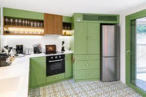 a kitchen with green cabinets and a refrigerator at Casa Di Nonno-Jacuzzi Mountain View Stay in Lesvos in Agiásos +17 photos