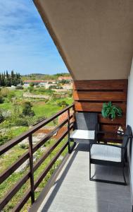 a balcony with a bench and a view of a field at Le Petit in Čilipi