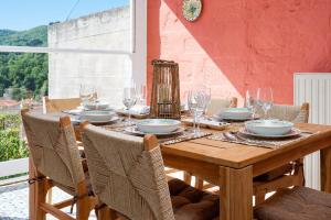 a wooden table with glasses and plates on it at Casa Di Nonno-Jacuzzi Mountain View Stay in Lesvos in Agiásos