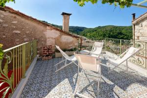 a patio with white chairs on a balcony at Casa Di Nonno-Jacuzzi Mountain View Stay in Lesvos in Agiásos