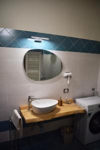 a bathroom with a white sink and a mirror at Il Loft Arona Centro, Le Dimore del Corso in Arona +10 photos