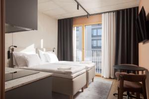 a hotel room with a bed and a window at Aarni Property in Jyväskylä