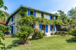 a blue and white house with a yard at Moulin de Lassalle in Linxe