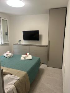 a bedroom with two beds and a flat screen tv at La Finestra sul Mare - Goelba in Chiessi