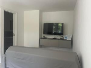 a bedroom with a bed and a flat screen tv at La Finestra sul Mare - Goelba in Chiessi