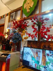 a computer monitor sitting on top of a table with flowers at sanoview in Kulu