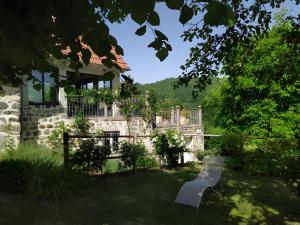 a stone house with a bench in the yard at Gîte de Pradevin in Jou-sous-Monjou