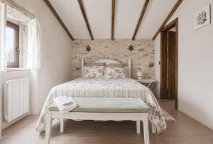 a bedroom with a bed and a stone wall at Casas de Xisto in Mogadouro