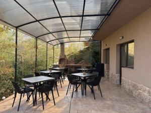 a patio with tables and chairs under a glass ceiling at Relax Boutique House in Kranevo