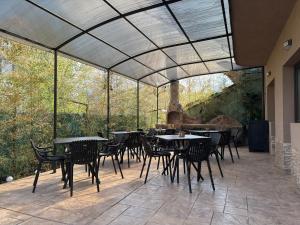 a patio with tables and chairs under a glass ceiling at Relax Boutique House in Kranevo +62 photos