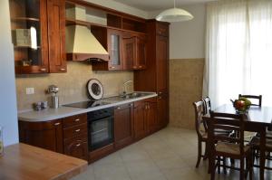 een keuken met houten kasten en een tafel met een eetkamer bij Monteverde Apartments in Acqui Terme