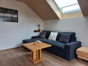 a living room with a blue couch and a table at Ferienwohnung Thomas in Landsberg am Lech