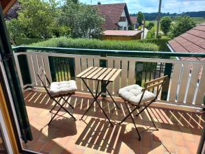 a wooden table and two chairs on a balcony at Ferienwohnung Thomas in Landsberg am Lech