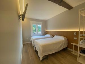two beds in a room with a window at PENSIÓN SANTA CLARA in Pontevedra