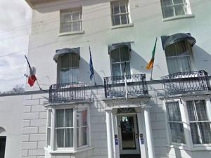 ein Gebäude mit Flaggen an der Vorderseite in der Unterkunft Thanington hotel in Canterbury