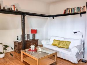 a living room with a white couch and a coffee table at Ferienwohnung im Hoetger-Hof in Worpswede