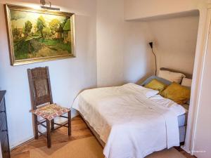 a bedroom with a bed and a chair and a painting at Ferienwohnung im Hoetger-Hof in Worpswede
