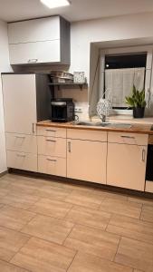 a kitchen with white appliances and a wooden floor at Gemütliche 60m2 Wohnung mit Terasse in Künzing