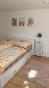 a bedroom with a white bed and a night stand at Gemütliche 60m2 Wohnung mit Terasse in Künzing
