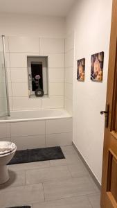 a white bathroom with a tub and a toilet at Gemütliche 60m2 Wohnung mit Terasse in Künzing +6 photos