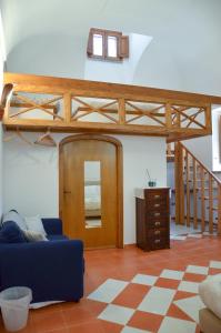 a living room with a blue couch and a loft bed at L'Antico Episcopio in Scala