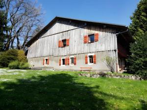 an old barn with orange shutters on a green field at La chambre Kimono in Onnion