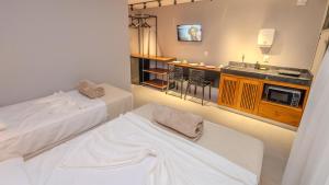 a hotel room with two beds and a sink at Ap Passarela in Porto Seguro +21 photos