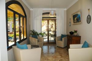 a living room with chairs and a table with blue pillows at Les Flots Bleus in Porto Ota