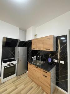 a kitchen with stainless steel appliances and wooden cabinets at Enea Apartments 8 in Tirana